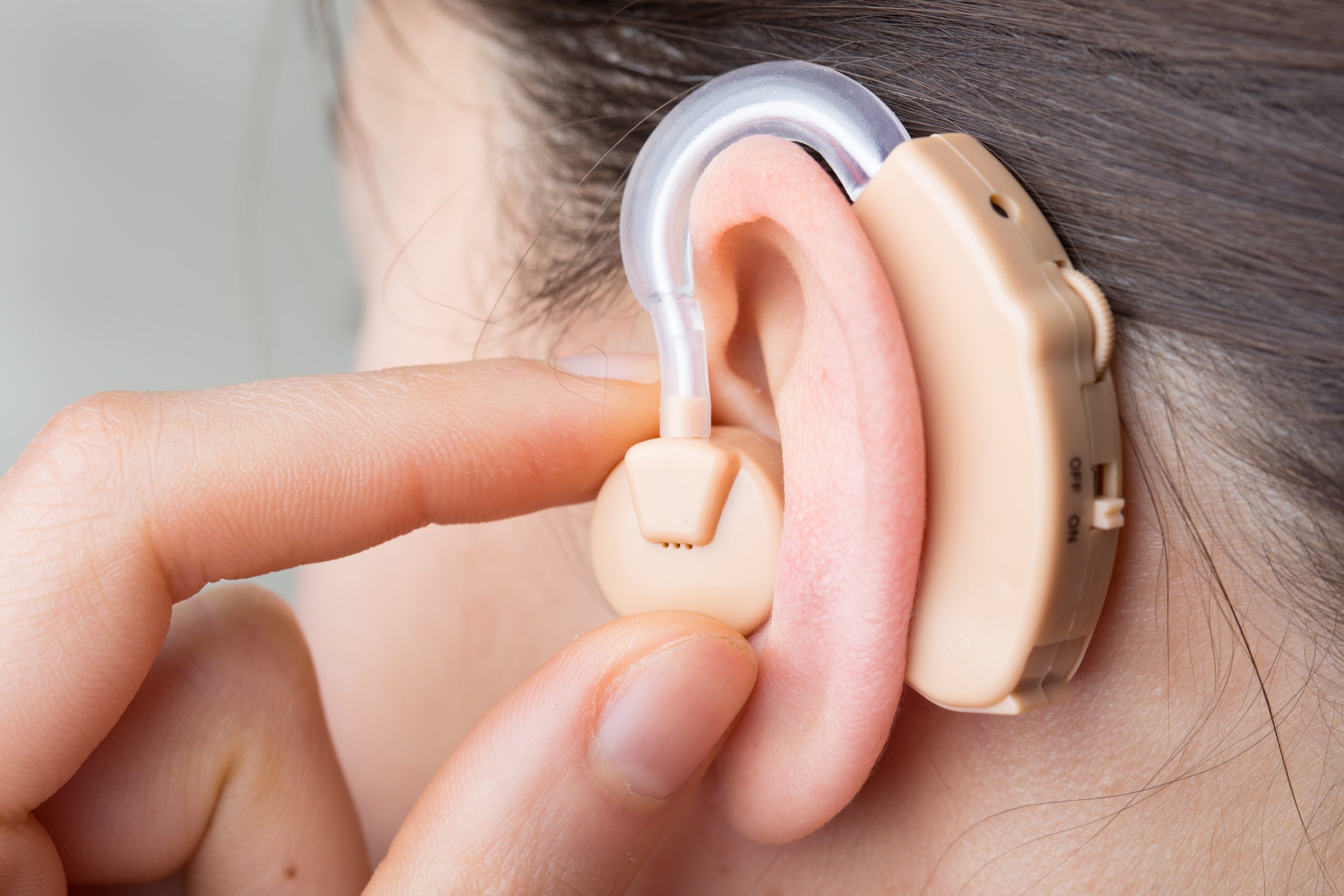 a-girl-touching-her-behind-the-ear-cochlear-implant-scaled