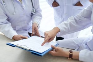 cropped-doctors-discussing-medical-document-team